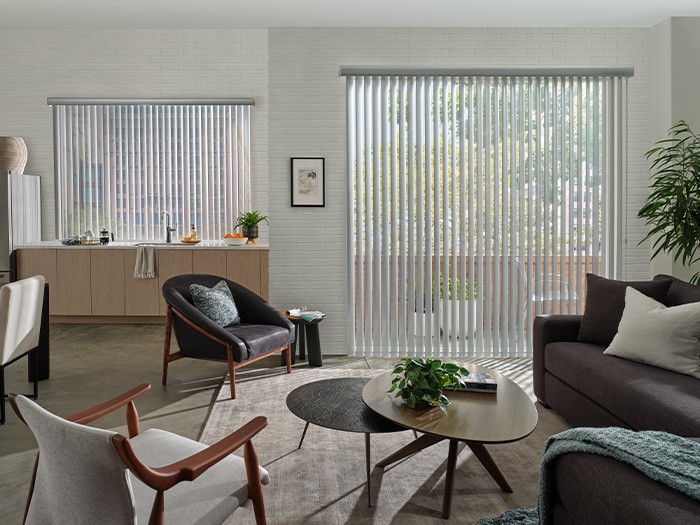 Living room with sliding glass doors featuring Somner® Custom Vertical Blinds  Color: Zinc Perforated